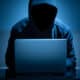 hacker dark face using laptop in the dark room